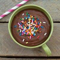 A vintage green coffee cup filled with homemade chocolate pudding.