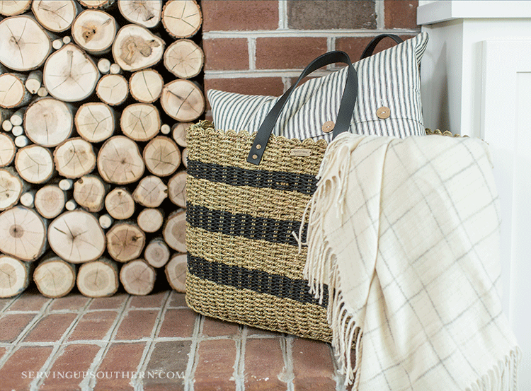 How to make a stacked wood fireplace / A straw bag, pillow, and throw sitting on a hearth.