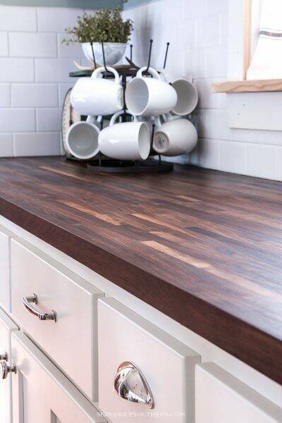 Walnut butcher block on white cabinets