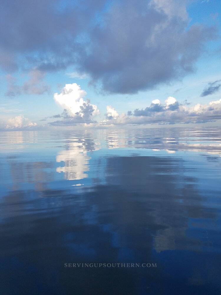 Big white puffy clouds reflecting in the glassy water of the Pamlico Sound.