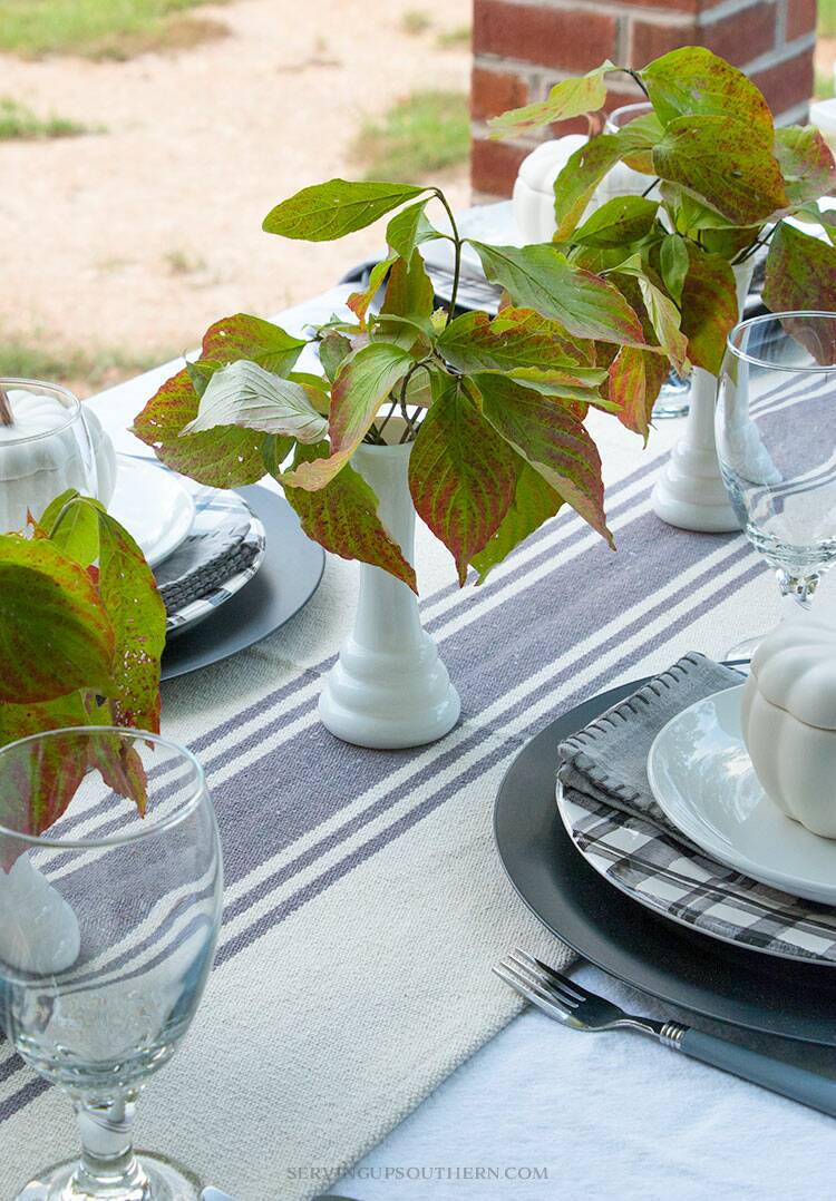 Table decorated for fall on a back porch.