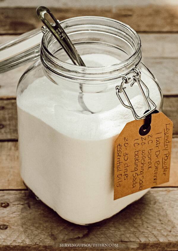 Homemade laundry detergent in a glass jar with a tag attached that includes the recipe.