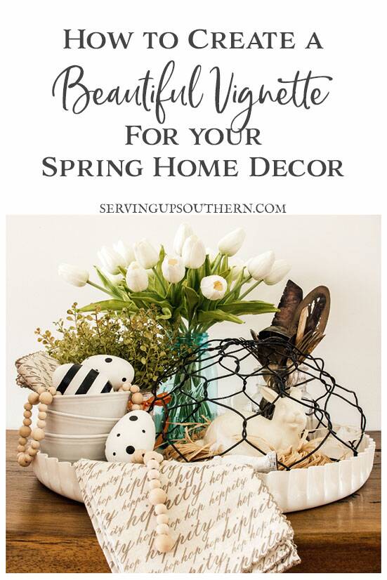 Spring vignette on a white metal tray decorated with spring and Easter decor sitting on wood table