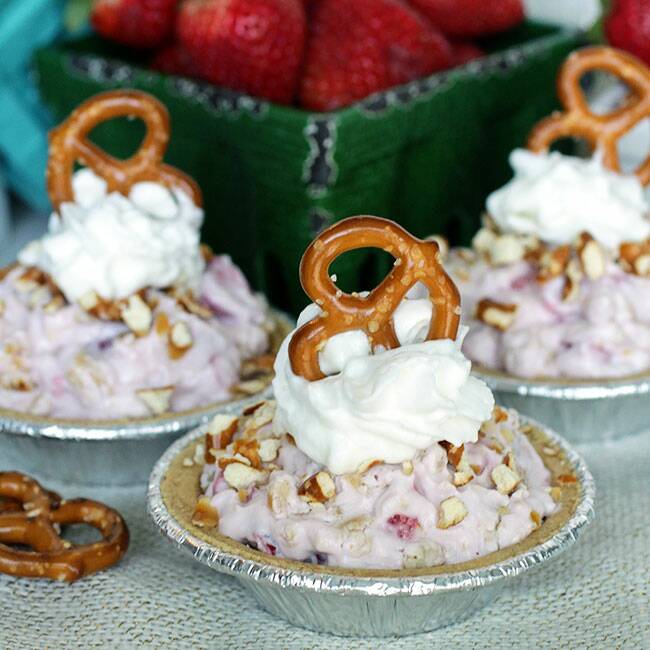 homestyle gathering mini pretzel parfaits on a linen cloth with strawberries in the background