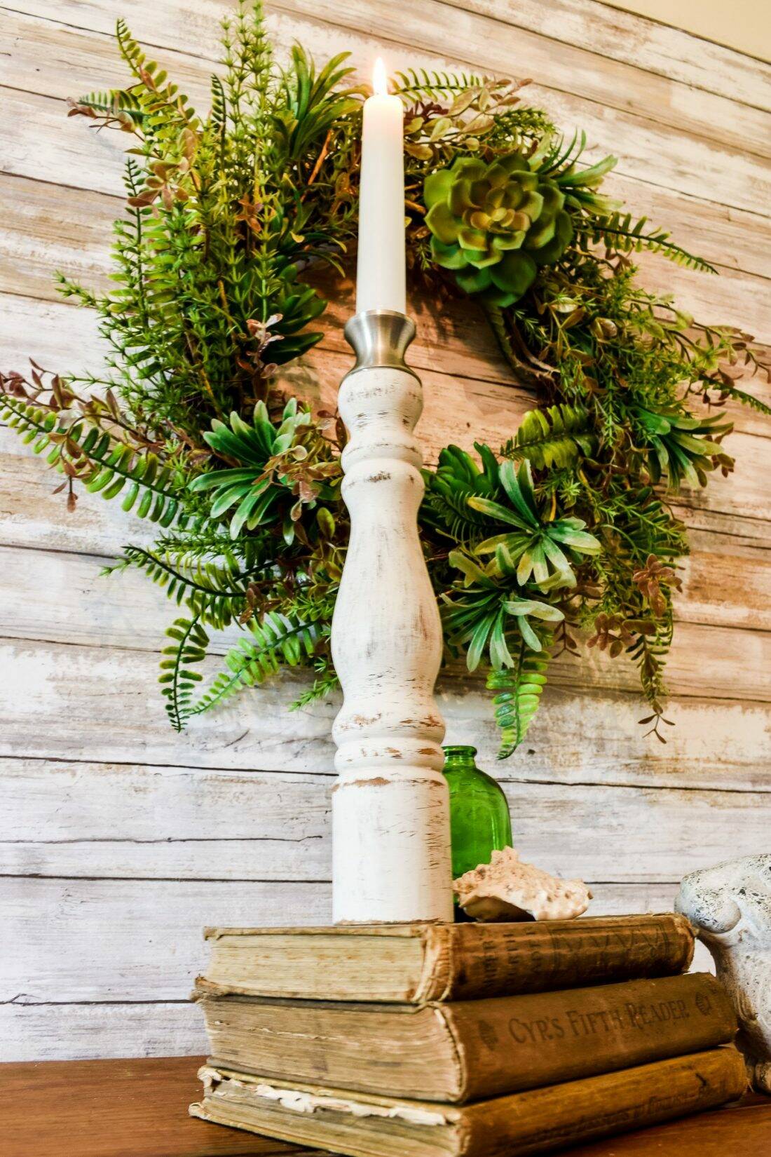 homestyle gathering candlestick with wreath in background on wood covered wall