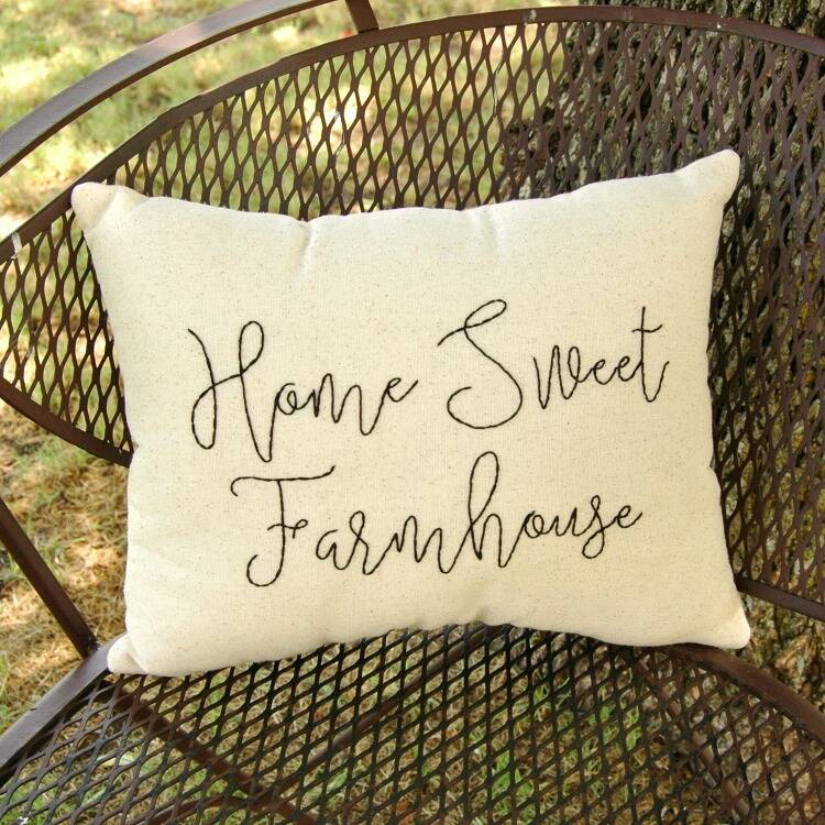Pillow with "Home Sweet Farmhouse" embroidered on it.