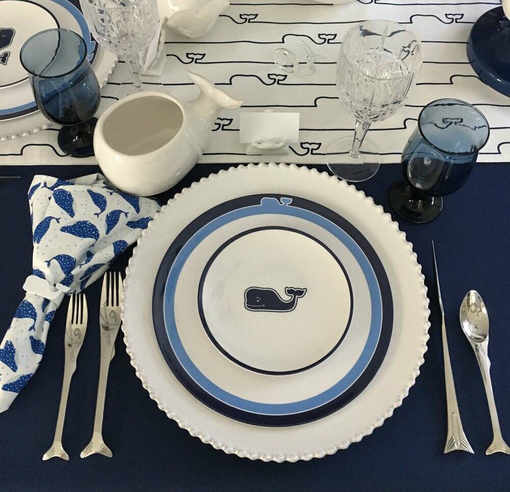 Coastal table setting in blues with a whale theme.