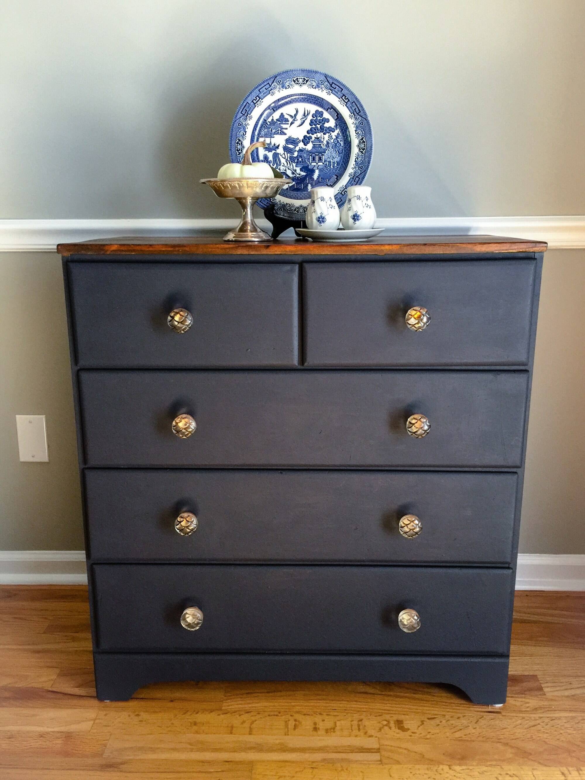 Wooden chest that has been painted navy with new glass knobs.