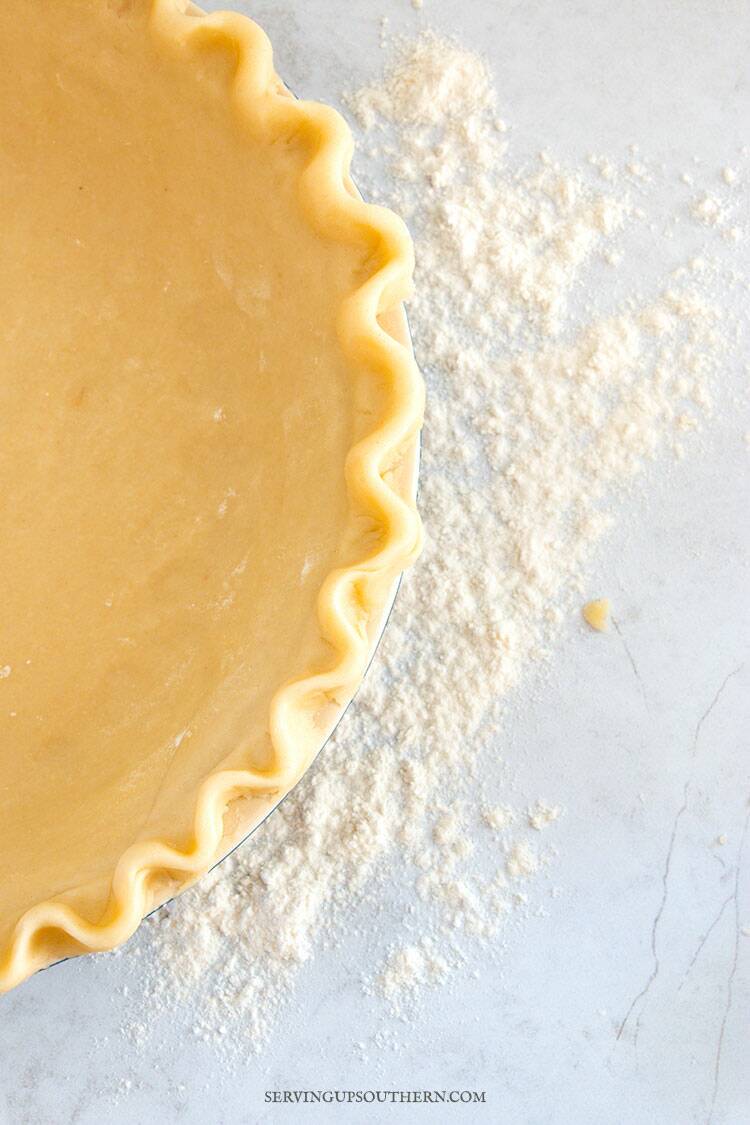 Close of image of the edge of a crimped homemade pie crust dough