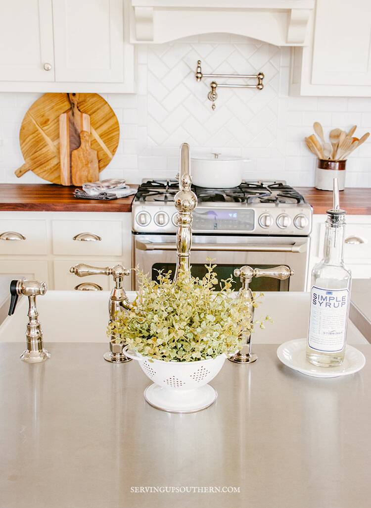 Picture of kitchen sink with oven and countertop in the background