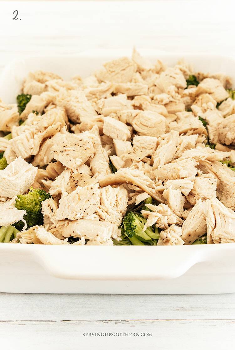 White casserole dish filled with lightly steamed broccoli and chicken.