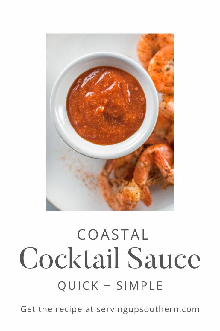 Small bowl of homemade coastal cocktail sauce surrounded by steamed shrimp on one side.
