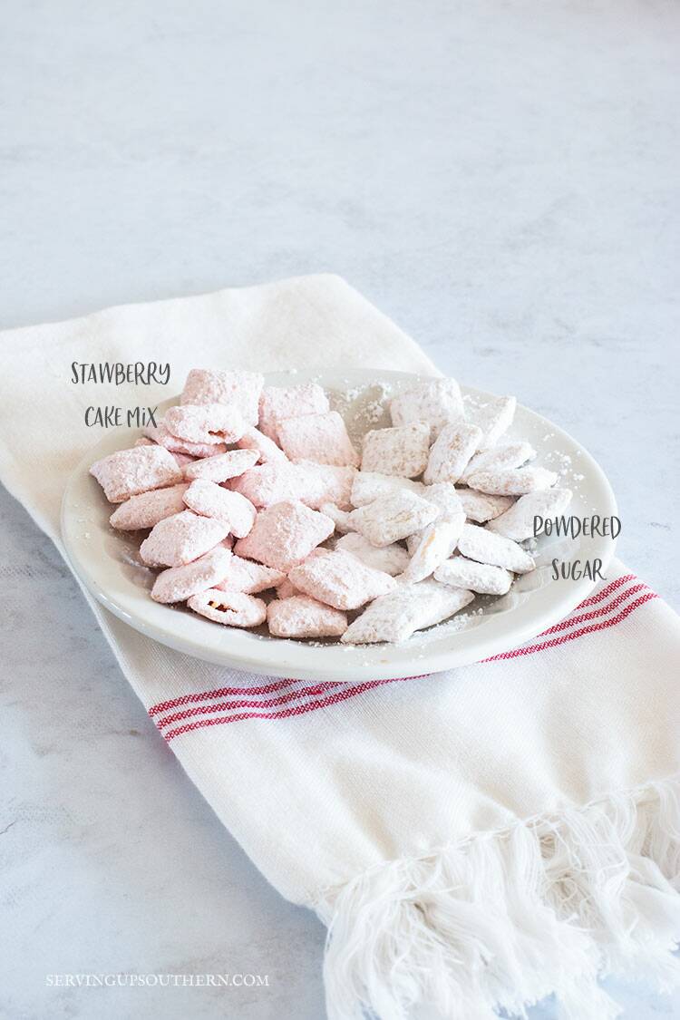 A dish with Chex cereal on it - half coated in powdered sugar the other half coated in strawberry cake mix.