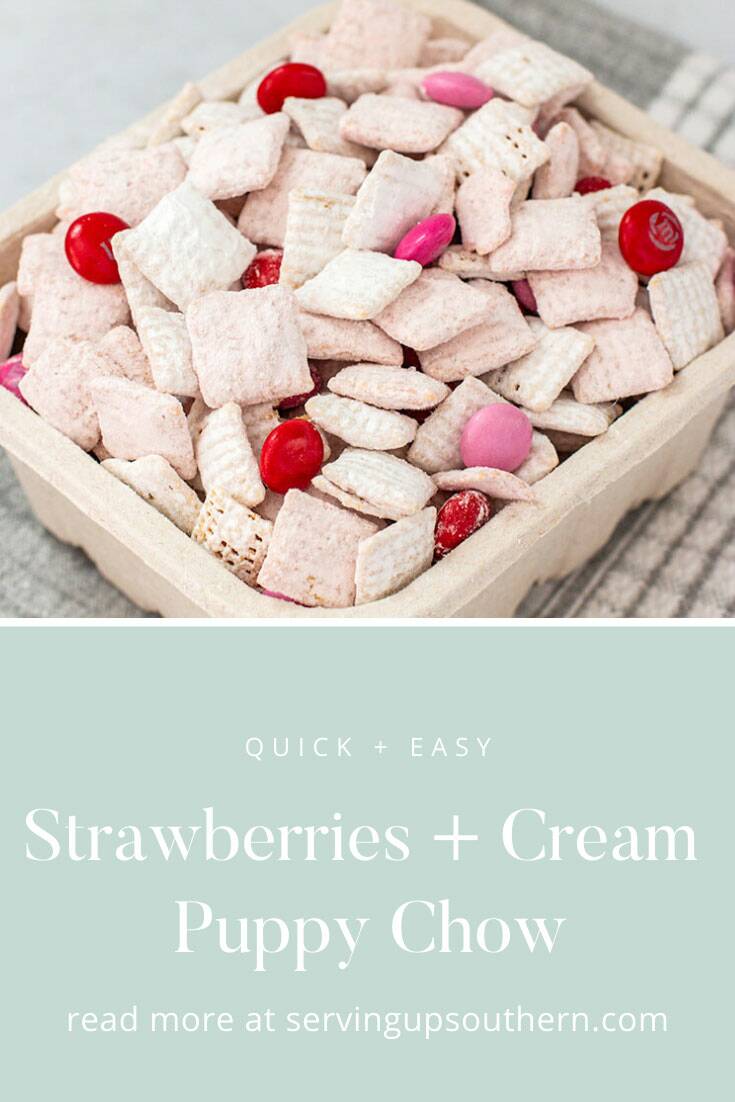 Pinterest graphic of a berry basket filled with strawberries and cream puppy chow snack setting on a marble surface.