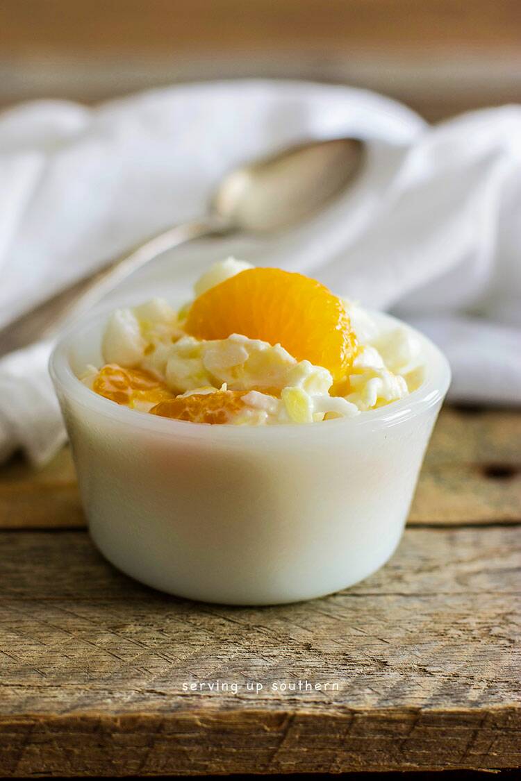 White dessert bowl filled with 5-cup salad on a rustic pallet board