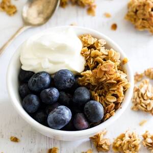 bowl of homemade granola topped with blueberries and yogurt.