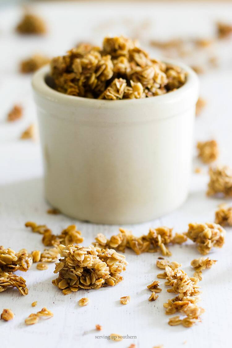 Picture of a small crock overflowing with homemade granola freshly toasted and right out of the oven.
