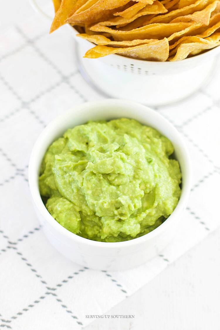 A close of shot of guacamole in a white bowl.