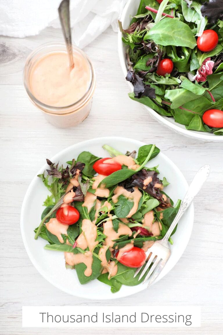 Pinterest graphic of plated salad with homemade thousand island dressing on a light wooden board.