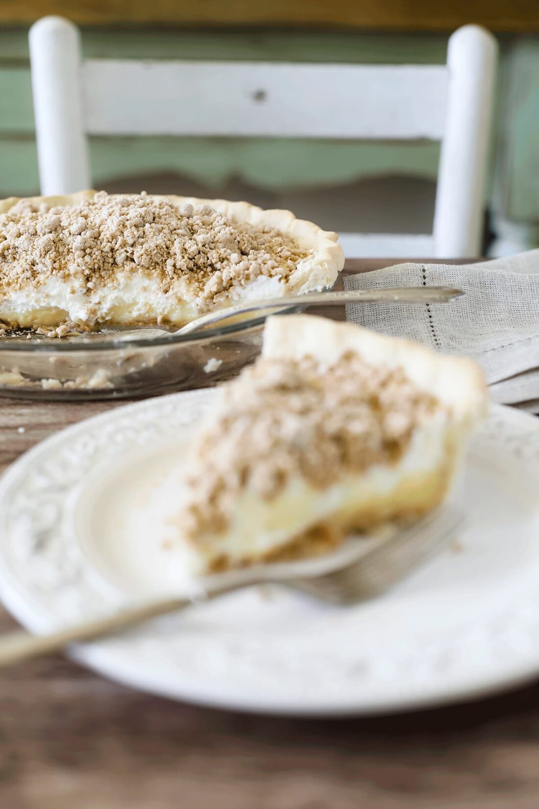 Old Fashioned Peanut Butter Pie and pies server set on a rustic wooden surface.